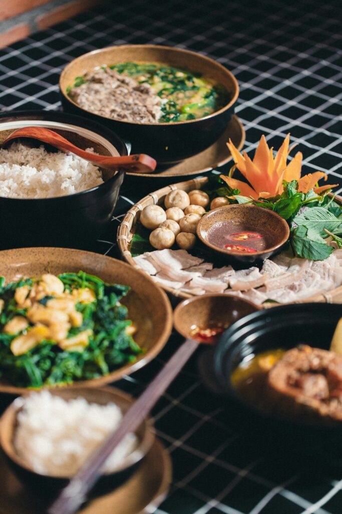 Shared Vietnamese meal with rice, meat, vegetables and dipping sauce